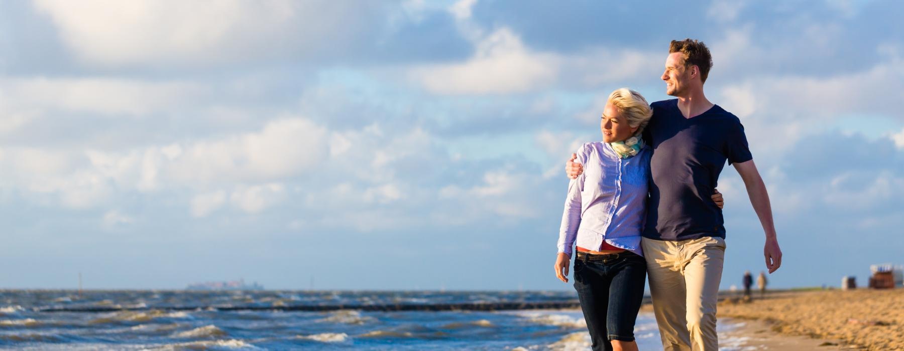 a man and woman walking on a beach